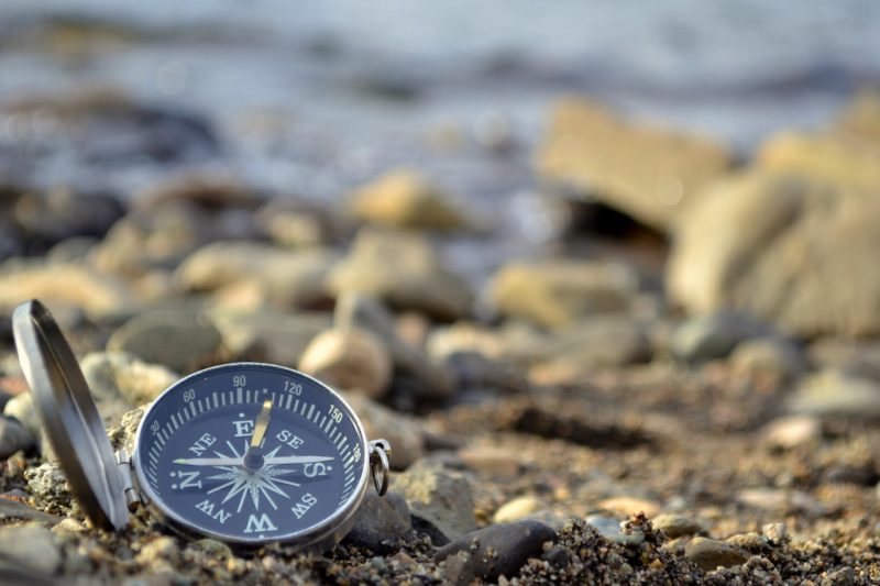 compass on rocky sandy beach